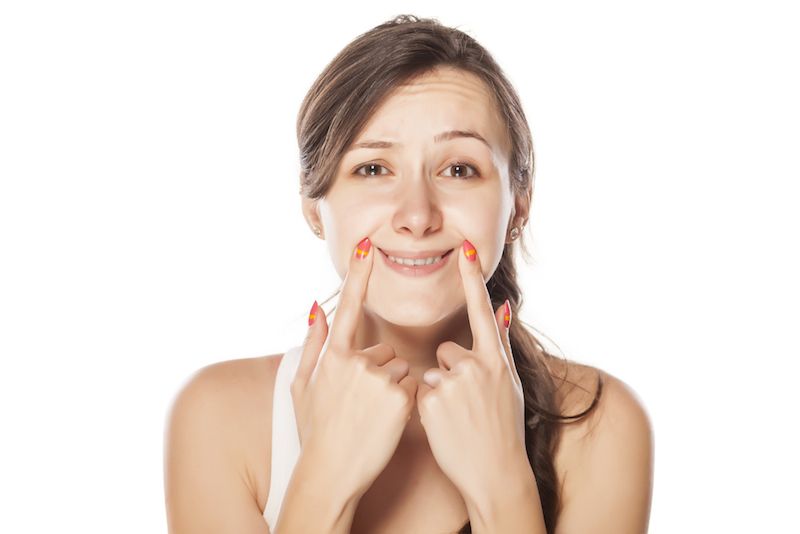 A young woman pushes her lips into a smile.