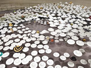 Made up of approximately 3000 white hats, the installation appears to be floating in Fumihiko Maki's Spiral Building exhibition space