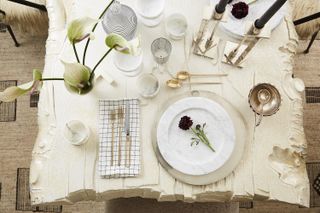 A white table with accents of gold Kelly Wearstler shows us how to decorate a Christmas table