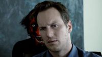The Lipstick Face Demon makes a wild face behind Patrick Wilson's Josh Lambert. 