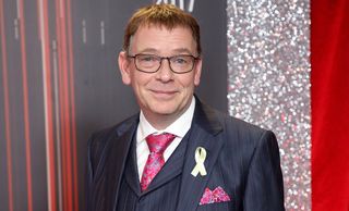 EastEnders star Adam Woodyatt on the red carpet wearing a suit. 