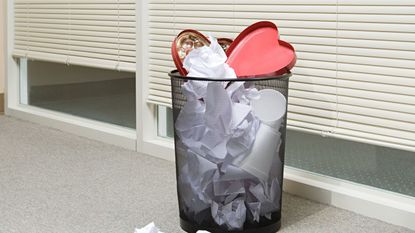 Heart-shaped chocolate box in trash