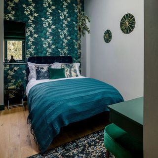 bedroom with hang teal wallpaper and wooden flooring