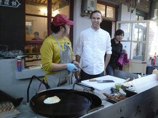 Two chefs at their street food stall, making breakfast crepes