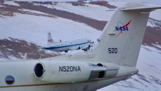 Two NASA planes above a white landscape.