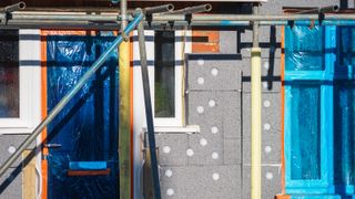 home with scaffolding while external wall insulation is being added