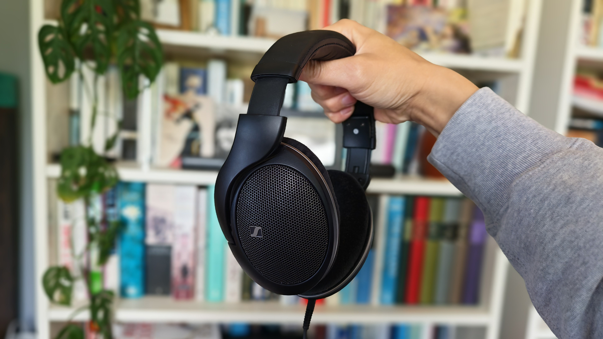 Three headphones in a row on a desktop.