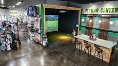 A Golf Direct Now store with golf gear on shelves, a virtual putting area, and their fitting center
