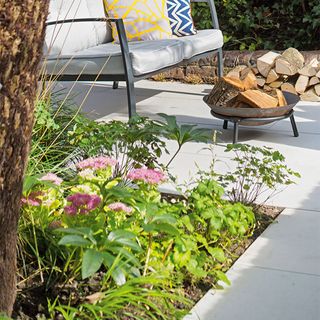 paving path with green plants and metal firepit