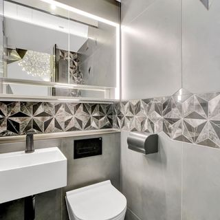 Grey bathroom with mirrors and patterned tiles