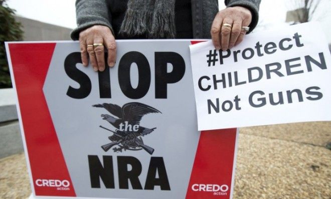 A protestor holds a banner during a march to the National Rifle Association headquarters on Capitol Hill on Dec. 17. 