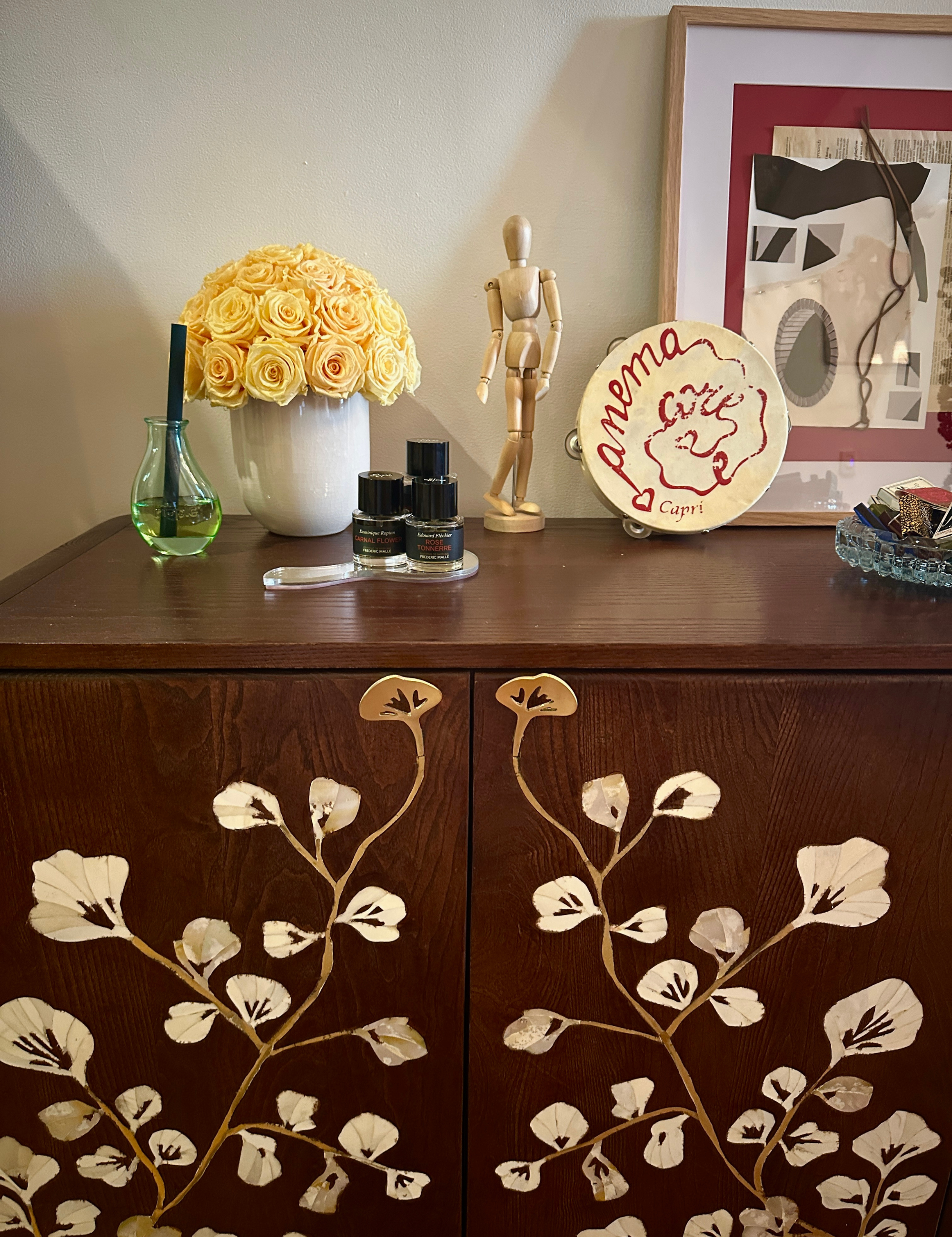 Ripple+ Home Reed diffuser sitting on a credenza filled with collected objects