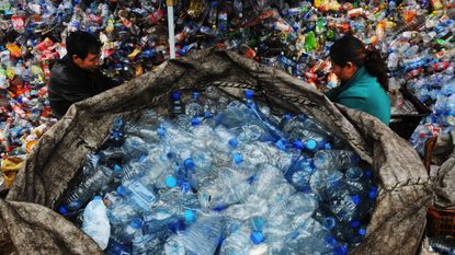 Two scrap collectors work at a plastics recycling mill in Wuhan, China