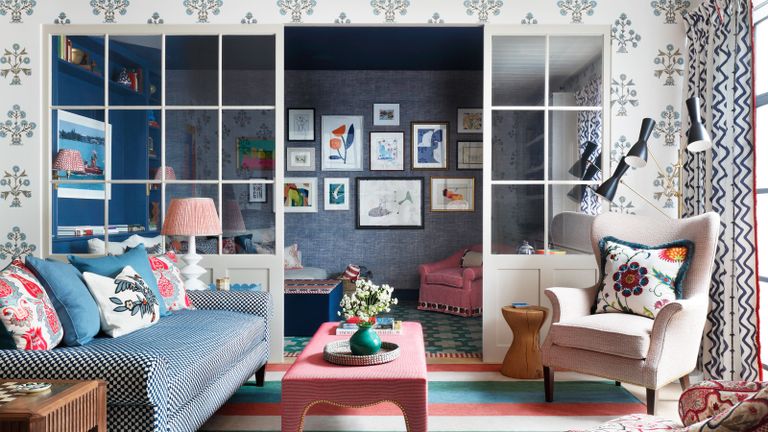 一个例子，破碎的计划客厅想法，显示蓝色沙发对面的奶油扶手椅，玻璃分开门前的明亮垫子