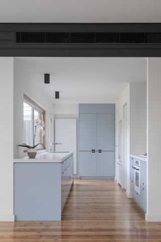 A kitchen with light blue cabinets and white walls