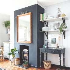 Black log burner in a white living room with statement blue painted chimney breast