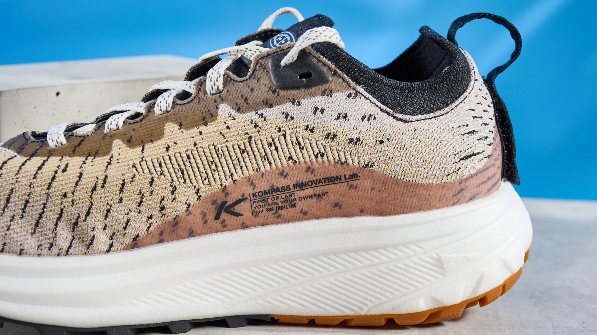 the keen seek trail shoes in brown, black, and beige photographed against the blue tom's guide background