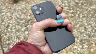 Someone holding an iPhone 12 mini in black
