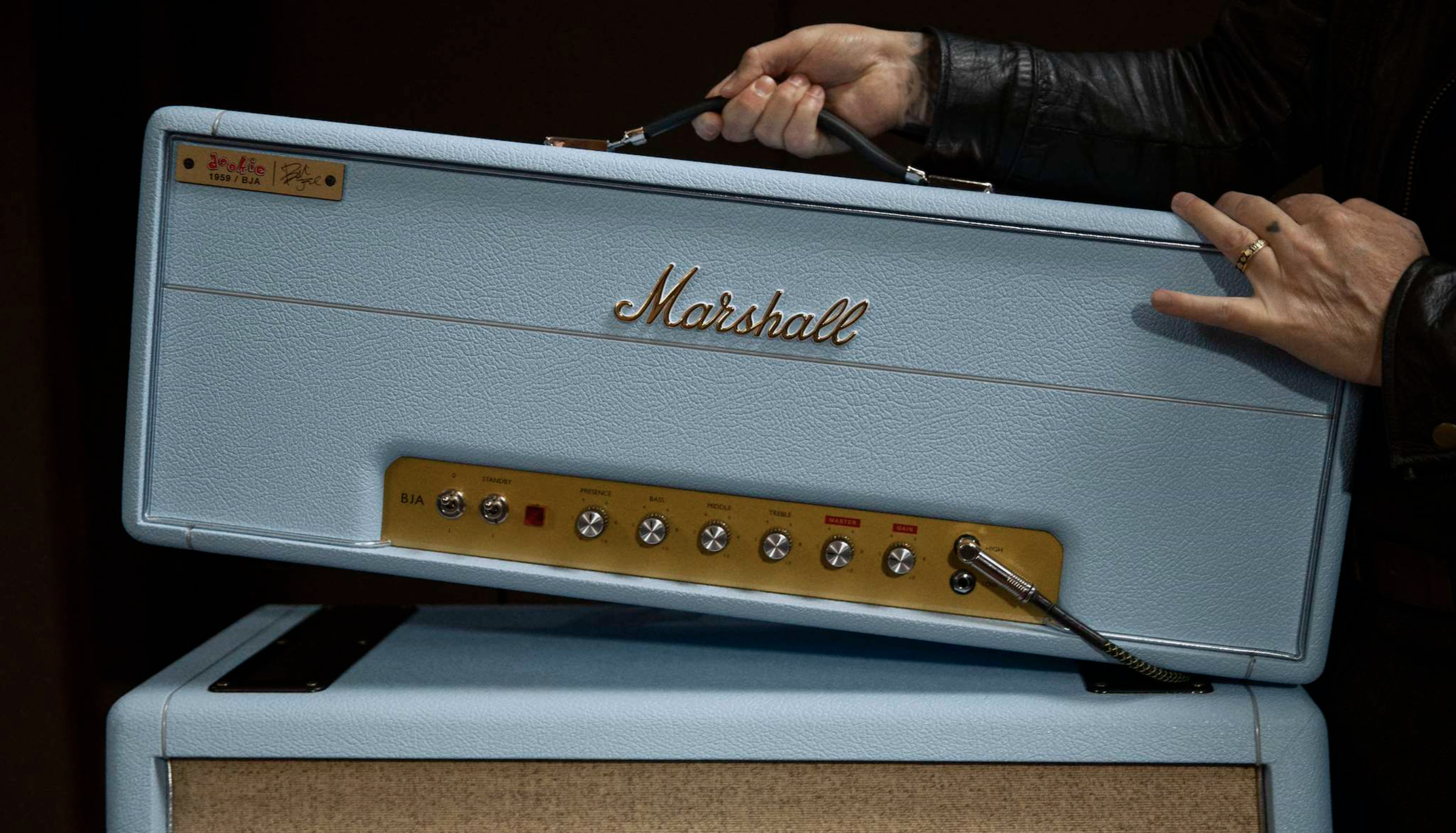 Marshall x Billie Joe Armstrong's baby blue guitar amp head, held by the star, whose arms are just visible