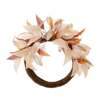 A fall wreath with a dark brown base and fabric white, pink, and orange petals on the top of it