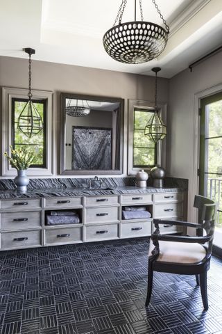 A bathroom with black and white floor tiles and black marble countertop