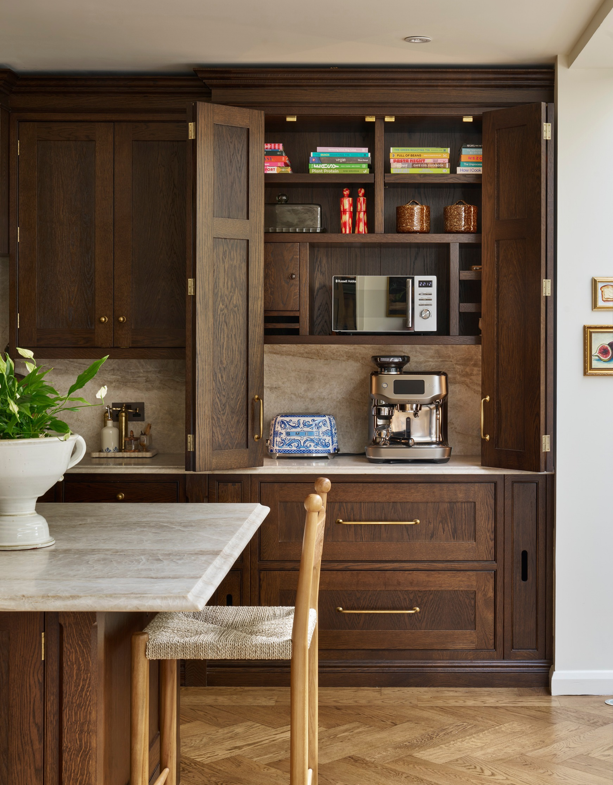 traditional, large kitchen with dark wooden cabinetry and a hidden pantry behind pocket doors