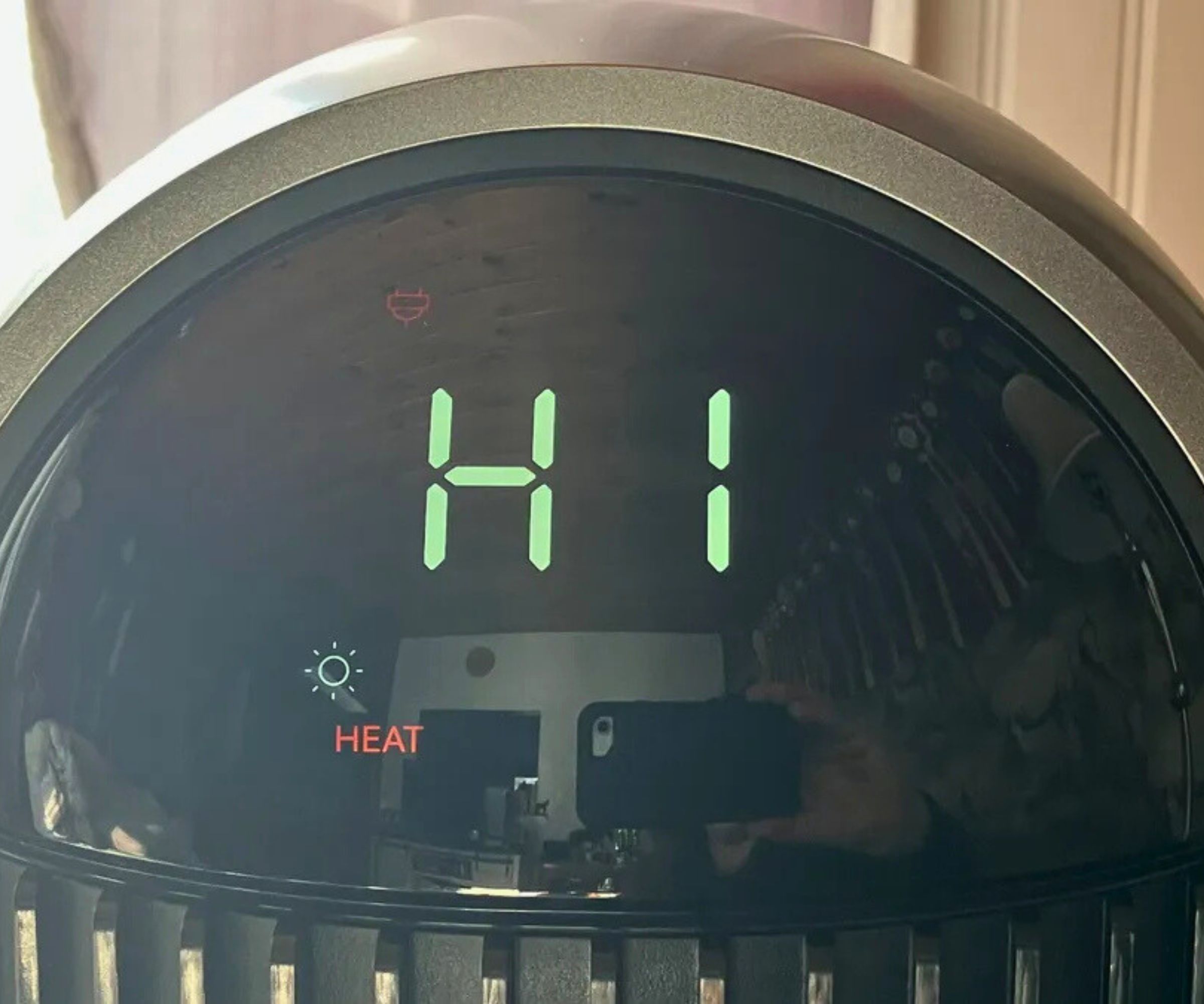 Photograph of the Dreo 2-in-1 Tower Fan and Heater MC706's LCD screen displaying text 'H1' and 'HEAT' – showing the lowest heating setting.