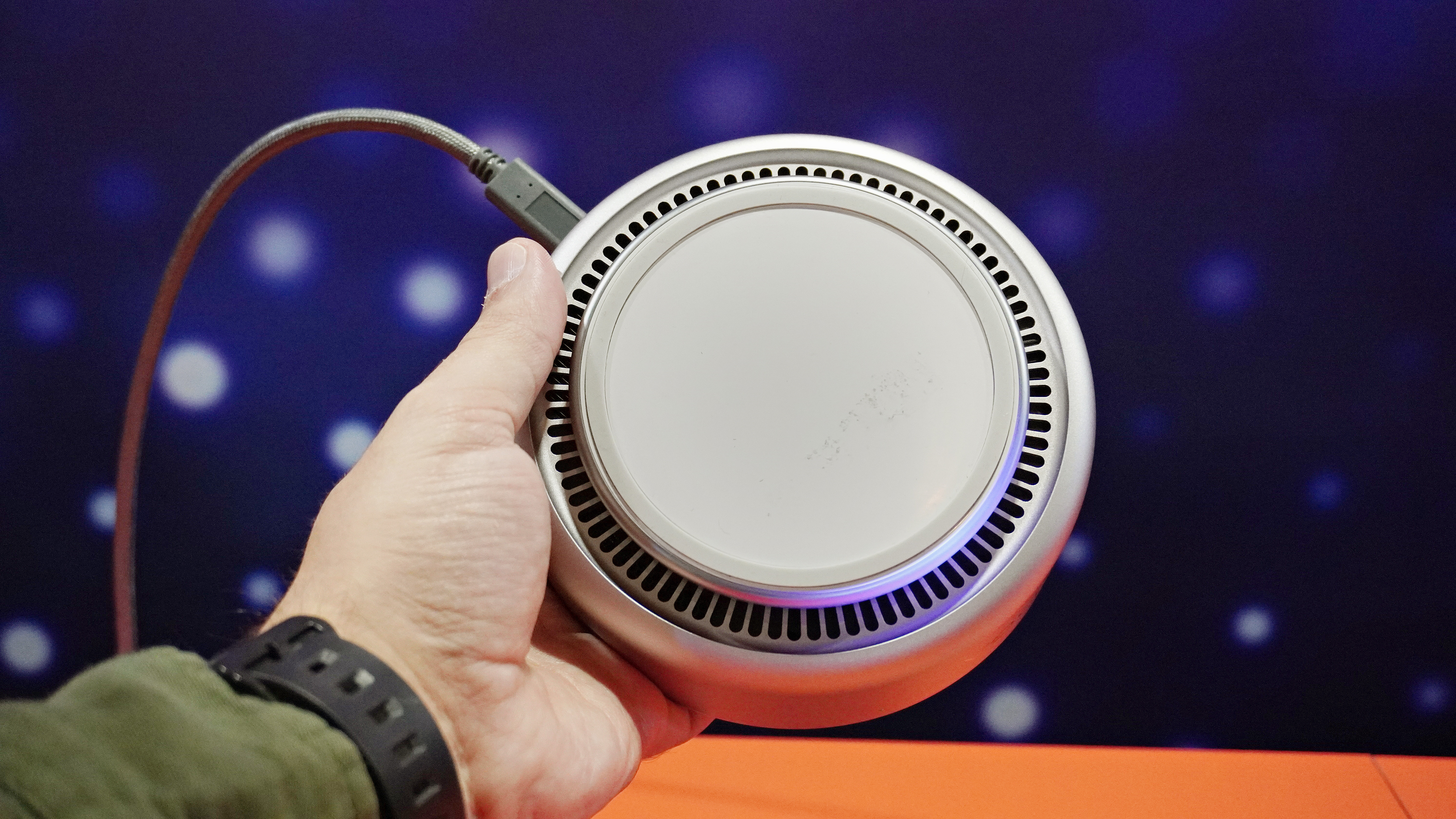 A person holding the Lenovo Yoga Mini i showing off the underside of this mini PC