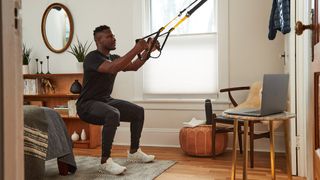 Athletic person using a TRX suspnsion trainer in their home