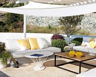 A white shade sail over a contemporary seating area
