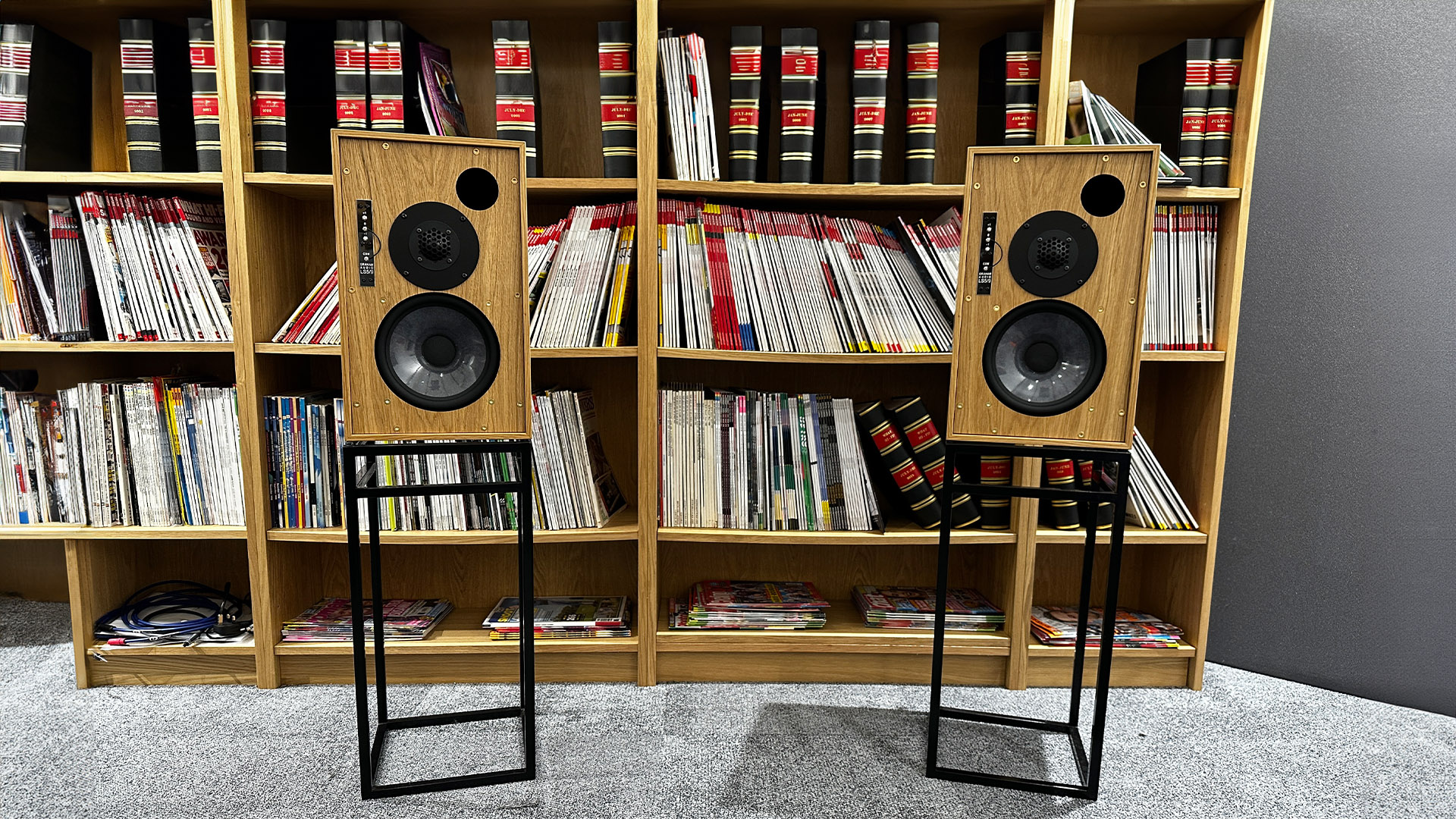 Graham Audio LS5/9 standmount speakers on stands in front of bookshelves