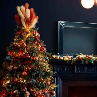Christmas tree topped with orange and peach feathers