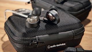 Pair of Audio-Technica in-ear monitors sat on a case