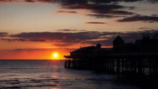 Sunset over seascape with pier
