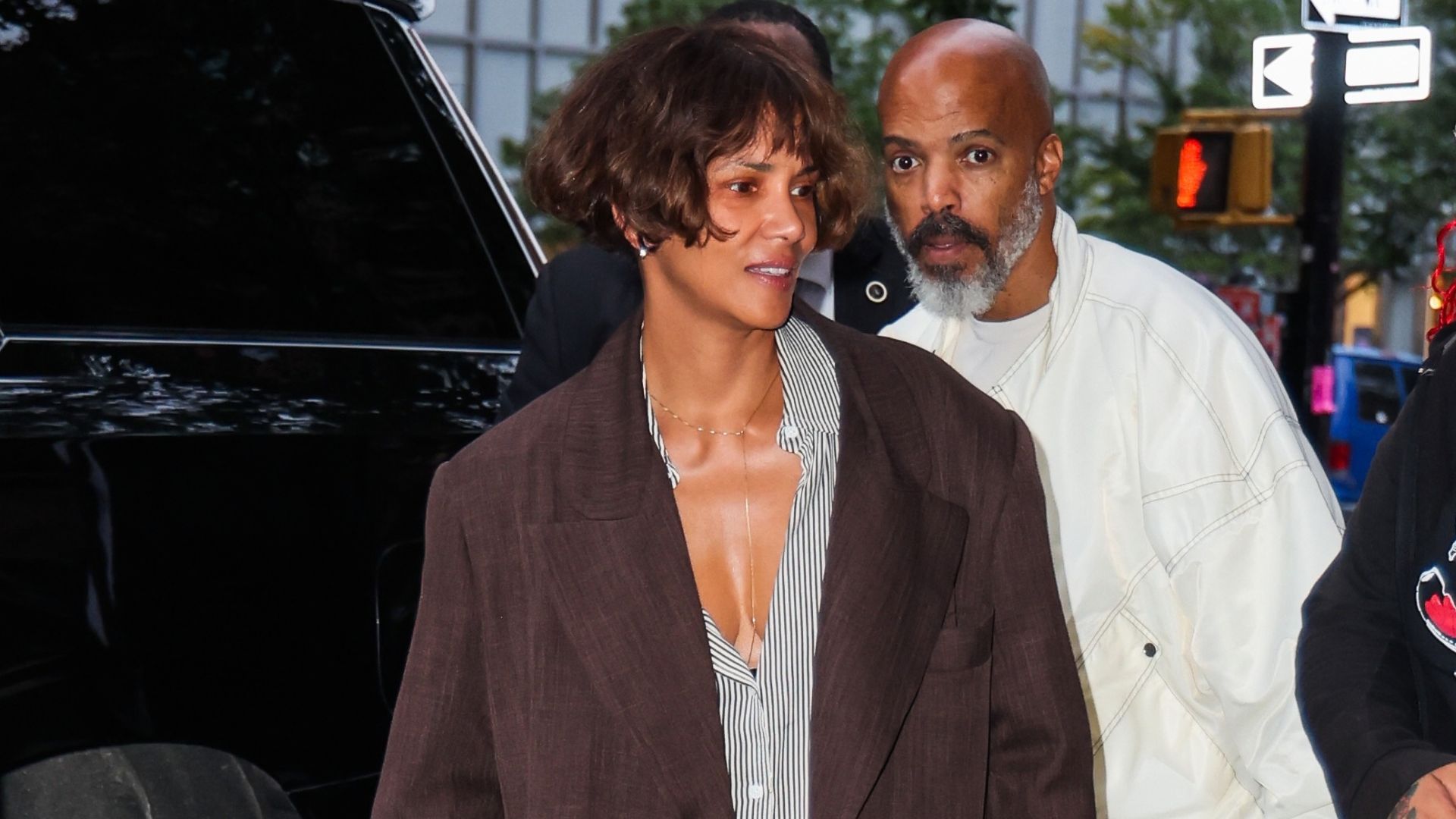 Halle Berry steps out of a car wearing an oversized blazer with cropped barrel-leg jeans, white trainers and an oversized shirt.