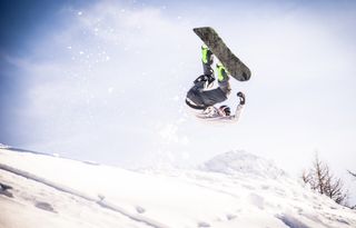 Snowboarder doing a trick in the snow.