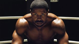 Michael B. Jordan as Adonis Creed, sitting in the corner of a boxing ring