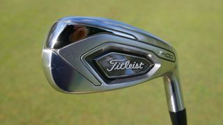 The stunning Titleist T400 Irons held aloft on the golf course showing their sleek clubhead design