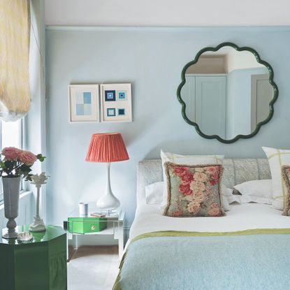 A bedroom with a wavy mirror above the bed