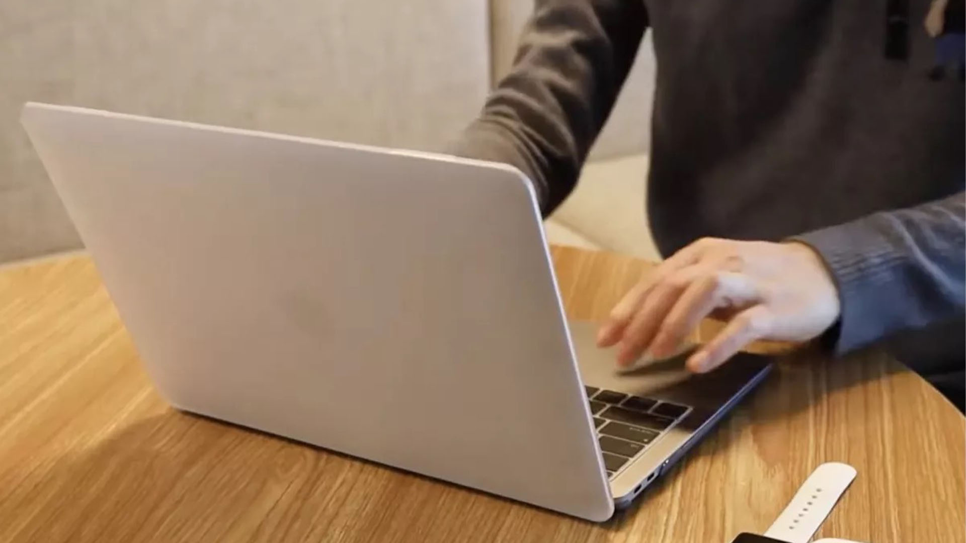 Seseorang menggunakan MacBook Pro mereka di meja dengan laptop yang ditutupi oleh Procase Macbook Pro Cover