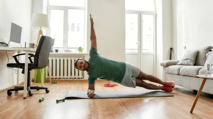 Man holding a side plank at home