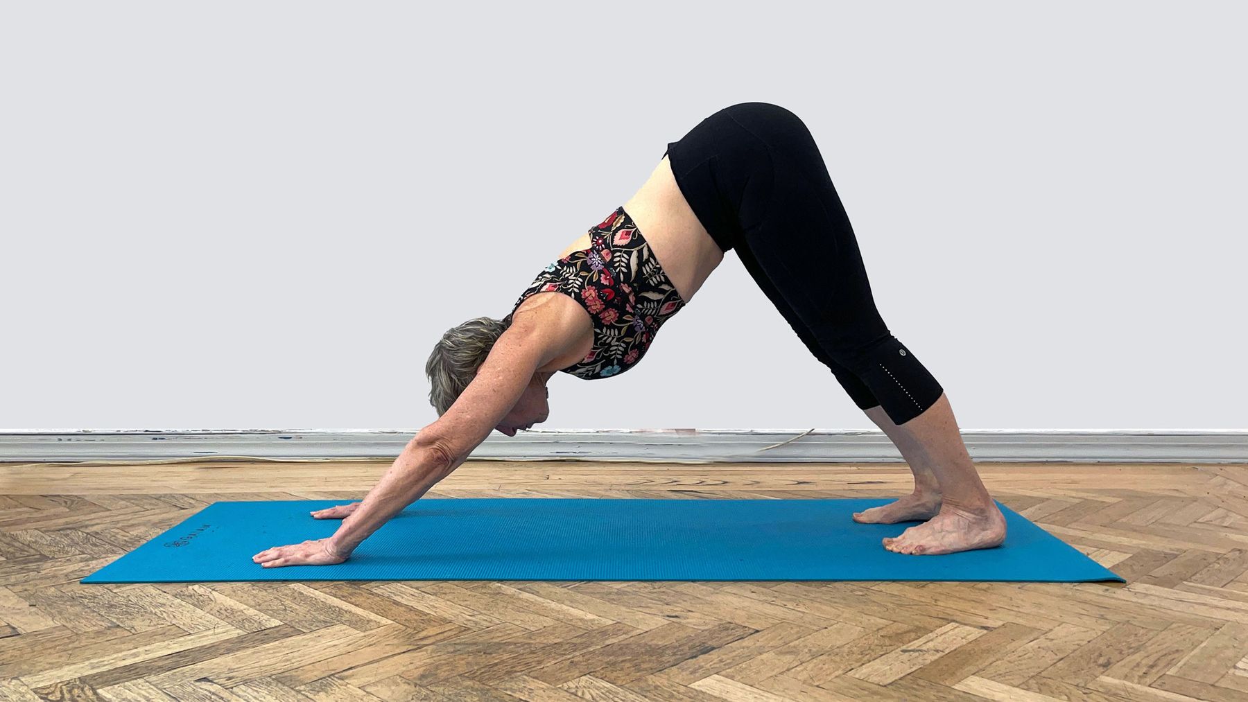 Jacqueline Gikow performing a downward facing dog stretch