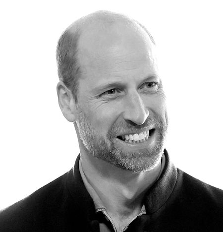 A black and white headshot photo of Prince William smiling and wearing a dark jacket