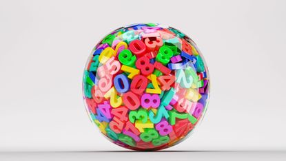 A clear ball containing lots of colourful plastic numbers
