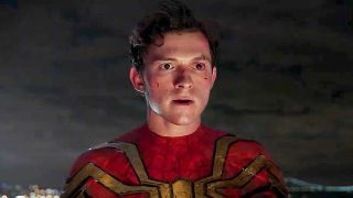 A scraped up and unmasked Peter Parker looking at something off-screen at night in Spider-Man: No Way Home