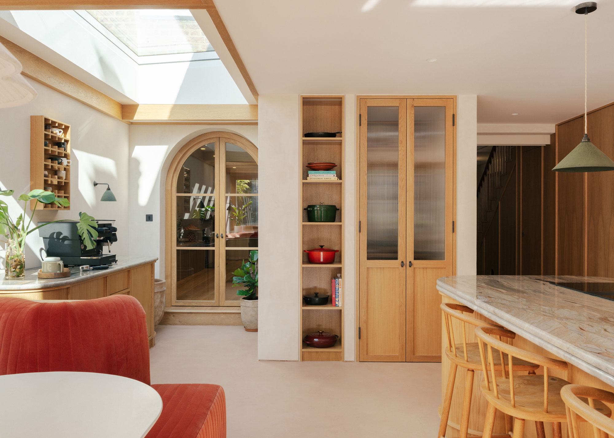 kitchen extension with red banquette seating and glazed arched doors