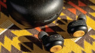 House of Marley Champion 2 true wireless earbuds on a beautifully colorful rug