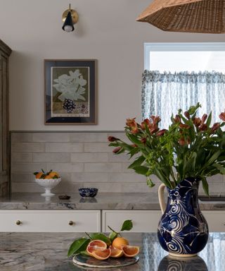 transitional kitchen with plenty of vintage acccessories and cafe curtains in a blue hue to match the countertops