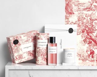 Dior pink Oud Ispahan fragrance on marble tabletop with the limited edition red Toile de Jouy packaging