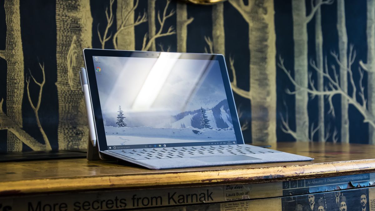 Microsoft&amp;#039;s Surface Pro tablet on a desk in front of a forest patterned wall